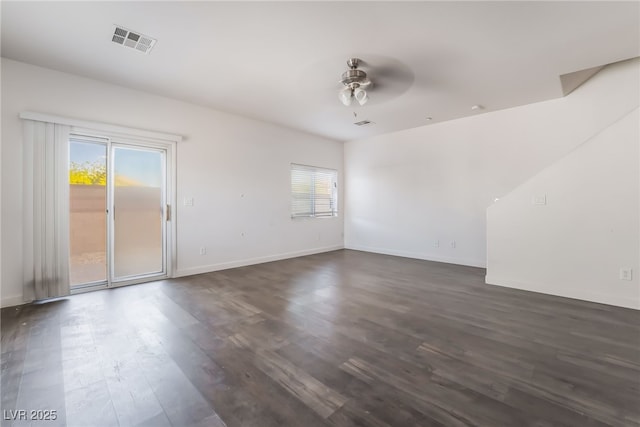 spare room featuring plenty of natural light, a ceiling fan, dark wood-style flooring, and baseboards