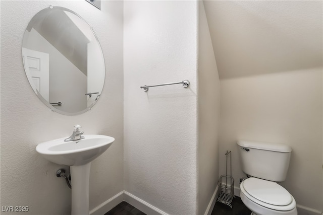 half bathroom featuring baseboards and toilet