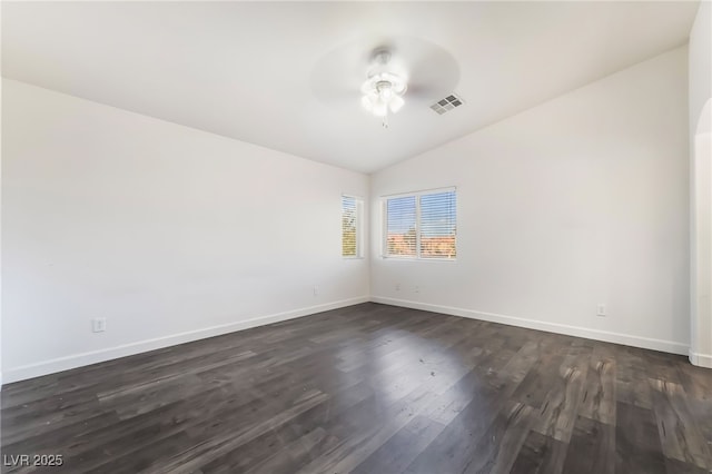 spare room with lofted ceiling, a ceiling fan, baseboards, and dark wood-style floors