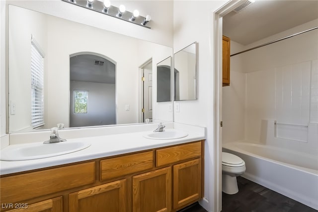 full bathroom with toilet, wood finished floors, double vanity, and bathing tub / shower combination