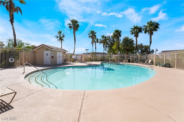 community pool with a patio area and fence
