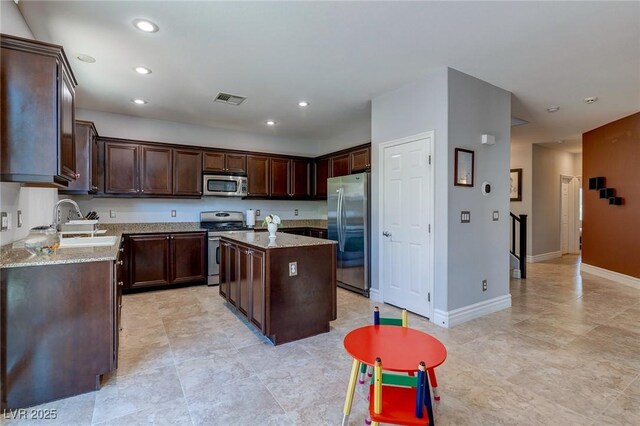 9780 Ziegler Ave, Las Vegas, NV 89148 - kitchen with stainless steel appliances, a sink, dark brown cabinets, a center island, and recessed lighting