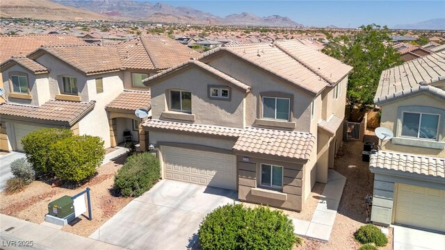 9780 Ziegler Ave, Las Vegas, NV 89148 - view of front of house with an attached garage, concrete driveway, a residential view, stucco siding, and a mountain view