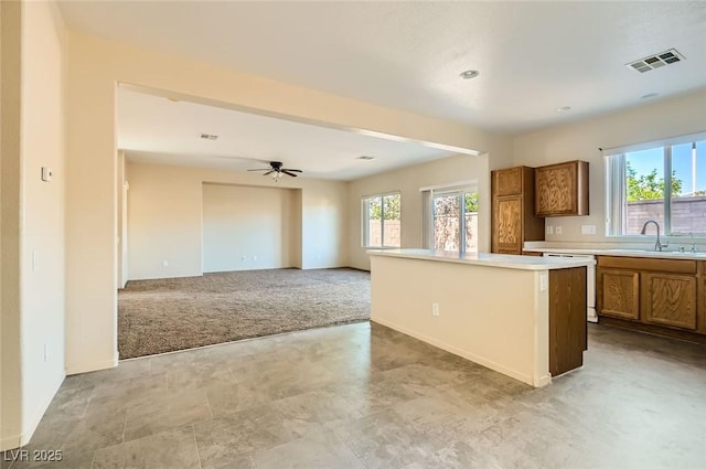 2728 Holmfault St, Henderson, NV 89044 - kitchen featuring a sink, dishwasher, brown cabinetry, and healthy amount of natural light
