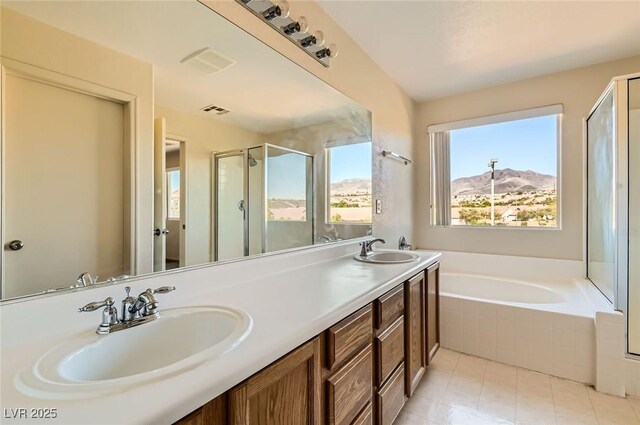 2728 Holmfault St, Henderson, NV 89044 - full bathroom with a shower stall, a garden tub, double vanity, a mountain view, and tile patterned floors