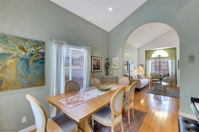 8388 Brad Oaks Cir, Las Vegas, NV 89123 - dining room with arched walkways, light wood finished floors, baseboards, and high vaulted ceiling