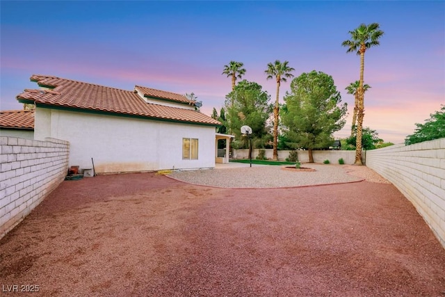8388 Brad Oaks Cir, Las Vegas, NV 89123 - back of property at dusk featuring a fenced backyard, a tile roof, and stucco siding
