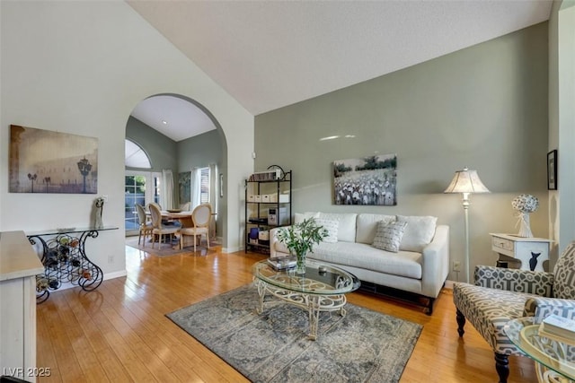 8388 Brad Oaks Cir, Las Vegas, NV 89123 - living area with arched walkways, wood-type flooring, high vaulted ceiling, and baseboards