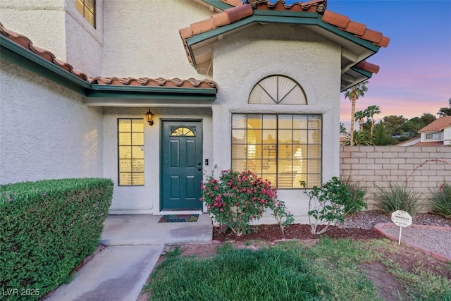 8388 Brad Oaks Cir, Las Vegas, NV 89123 - exterior entry at dusk featuring stucco siding, a tiled roof, and fence