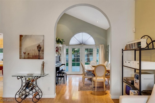 8388 Brad Oaks Cir, Las Vegas, NV 89123 - dining area featuring arched walkways, hardwood / wood-style floors, vaulted ceiling, french doors, and baseboards