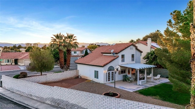 8388 Brad Oaks Cir, Las Vegas, NV 89123 - back of property at dusk with a patio, french doors, stucco siding, and a fenced backyard