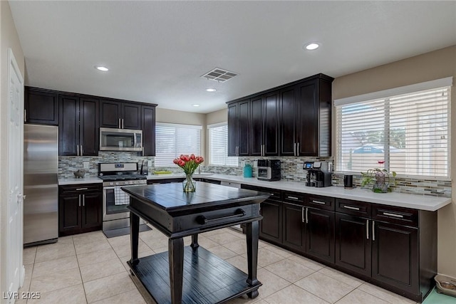 9469 Coral Shine Ct, Las Vegas, NV 89123 - kitchen featuring appliances with stainless steel finishes, backsplash, light countertops, light tile patterned floors, and recessed lighting
