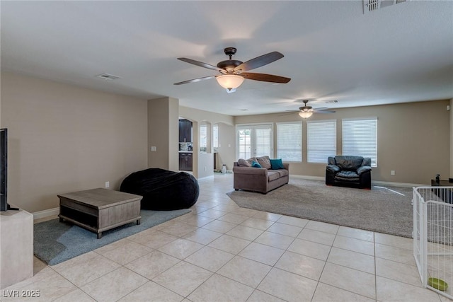 9469 Coral Shine Ct, Las Vegas, NV 89123 - living area featuring ceiling fan, light carpet, light tile patterned floors, baseboards, and arched walkways