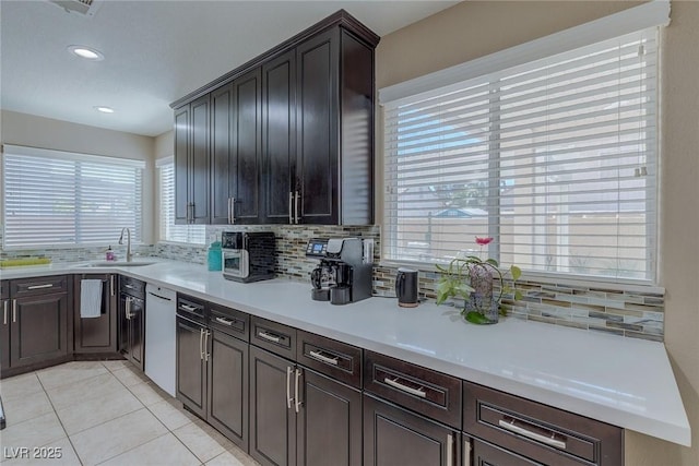9469 Coral Shine Ct, Las Vegas, NV 89123 - kitchen featuring a sink, backsplash, light tile patterned floors, light countertops, and dishwasher