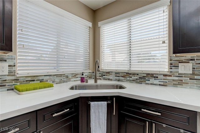 9469 Coral Shine Ct, Las Vegas, NV 89123 - kitchen with a sink, tasteful backsplash, light countertops, and dark brown cabinetry