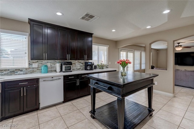 9469 Coral Shine Ct, Las Vegas, NV 89123 - kitchen with white dishwasher, light countertops, decorative backsplash, arched walkways, and recessed lighting