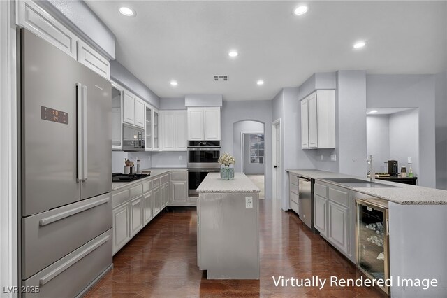 8809 Barium Rock Ave, Las Vegas, NV 89143 - kitchen featuring appliances with stainless steel finishes, beverage cooler, arched walkways, white cabinetry, and recessed lighting