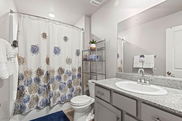 bathroom with toilet, vanity, and shower / bath combo with shower curtain