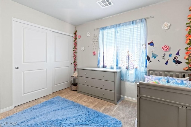 bedroom featuring light carpet, baseboards, and a closet