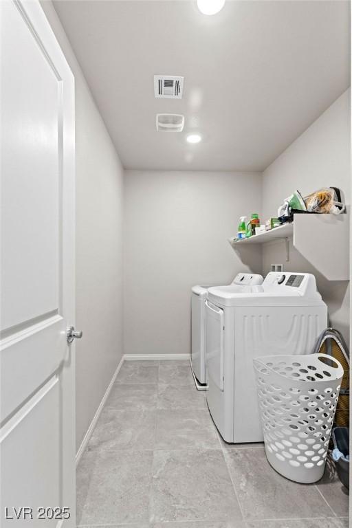 clothes washing area with washing machine and clothes dryer and baseboards