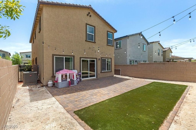 rear view of house featuring stucco siding, central air condition unit, and a patio area