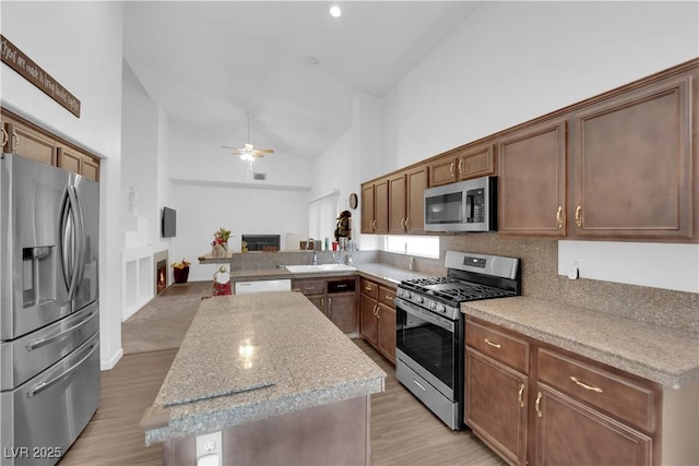 1893 Donnington Ct, Las Vegas, NV 89123 - kitchen featuring stainless steel appliances, a center island, light wood-style flooring, a ceiling fan, and open floor plan
