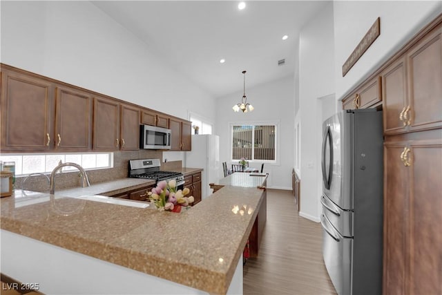 1893 Donnington Ct, Las Vegas, NV 89123 - kitchen with appliances with stainless steel finishes, high vaulted ceiling, wood finished floors, recessed lighting, and a chandelier