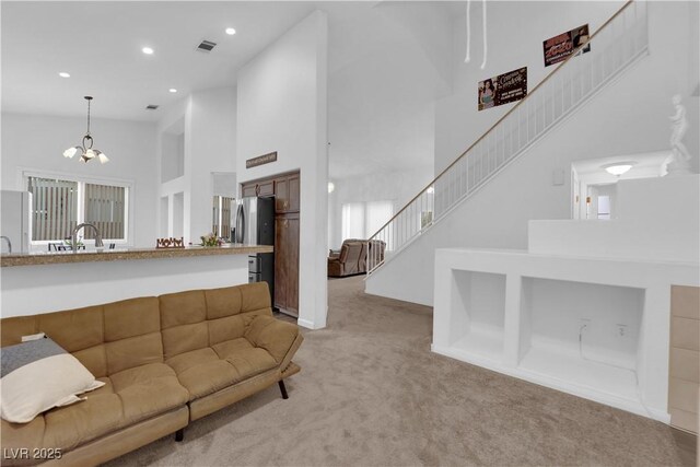 1893 Donnington Ct, Las Vegas, NV 89123 - living room featuring light colored carpet, a high ceiling, stairway, a chandelier, and recessed lighting