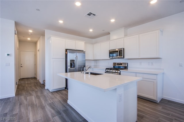 145 Aqua Commons Ln, Henderson, NV 89015 - kitchen featuring appliances with stainless steel finishes, a sink, white cabinetry, dark wood-type flooring, and recessed lighting