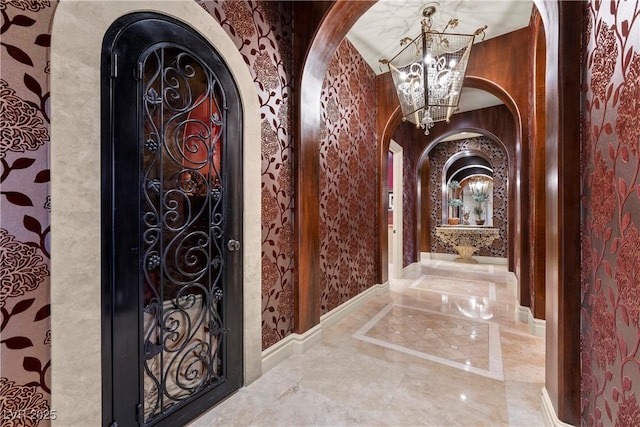 5079 Mountain Top Cir, Las Vegas, NV 89148 - hallway with arched walkways, a chandelier, and marble tiled flooring