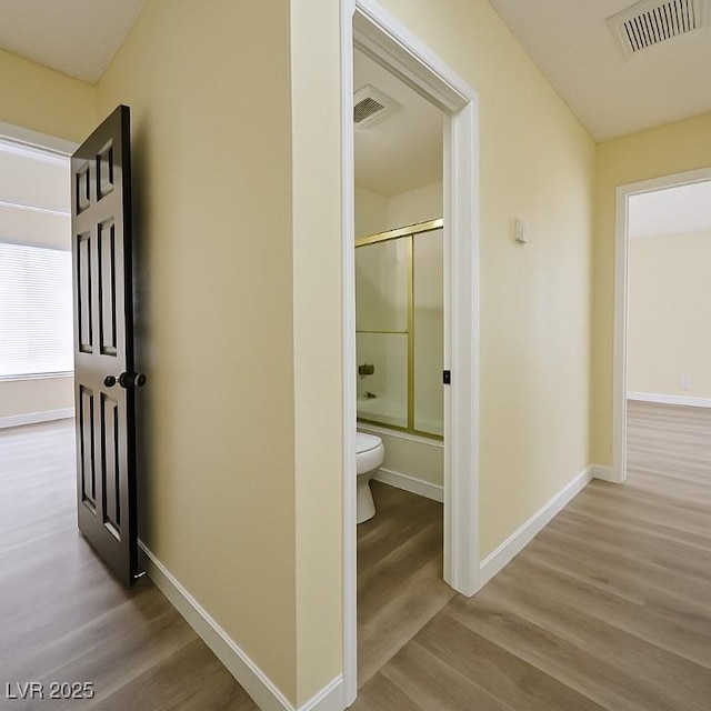 corridor with wood finished floors and baseboards