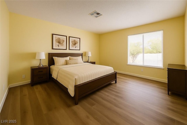 bedroom with wood finished floors and baseboards