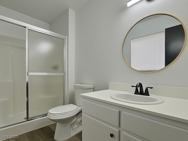 full bathroom with wood finished floors, a shower stall, toilet, and vanity