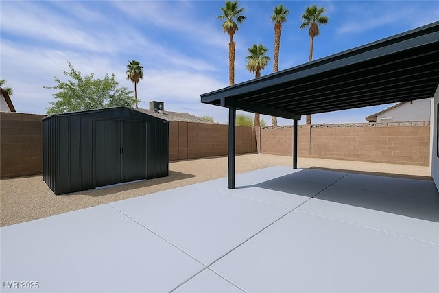 view of patio / terrace with a storage unit, an outbuilding, and a fenced backyard
