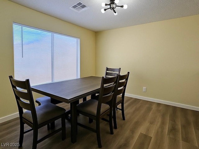 dining area featuring a chandelier, baseboards, dark wood-style floors, and a textured ceiling