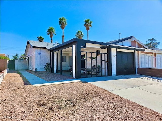 view of front of house with a garage, fence, driveway, and stucco siding