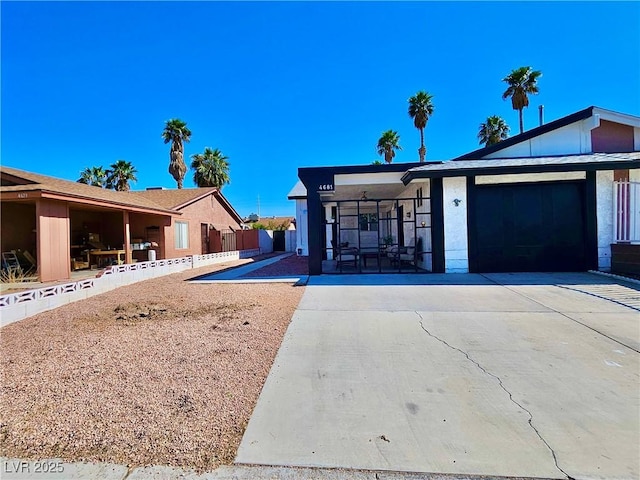 view of front of home with a garage, driveway, and fence