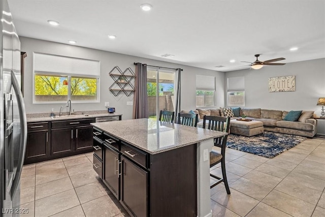 kitchen with a sink, a breakfast bar area, stainless steel fridge with ice dispenser, plenty of natural light, and recessed lighting