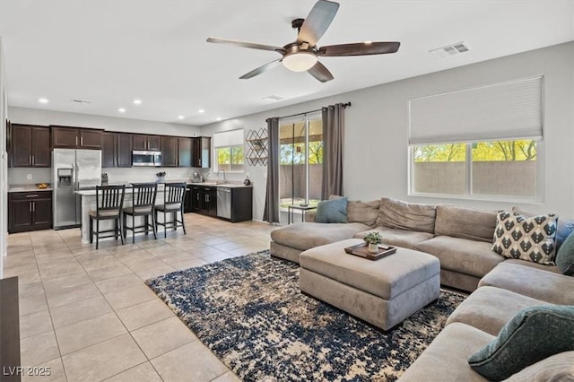 living area featuring light tile patterned floors, a ceiling fan, and recessed lighting
