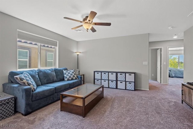 living area featuring carpet, a ceiling fan, and baseboards
