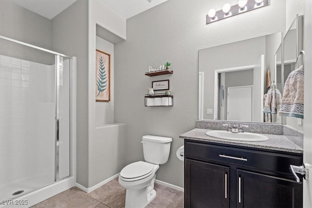 full bathroom with a stall shower, toilet, vanity, baseboards, and tile patterned flooring