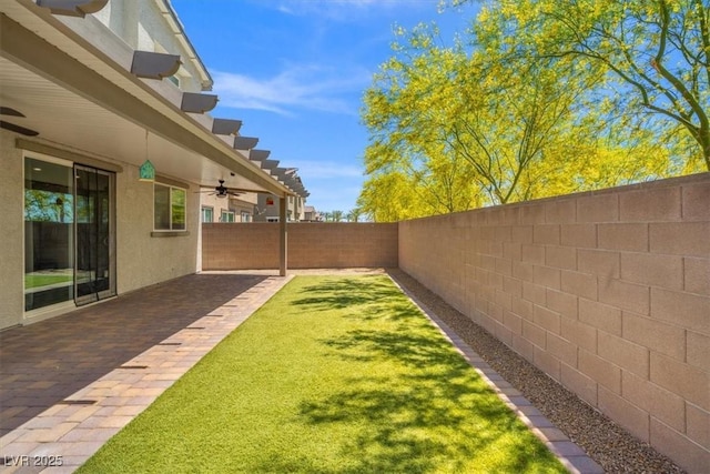 view of yard with a ceiling fan and a patio