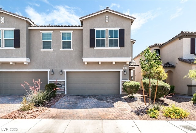 view of front of property with an attached garage, stucco siding, driveway, and a tile roof