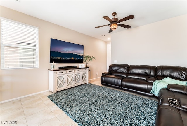 living area featuring ceiling fan, light tile patterned flooring, and baseboards