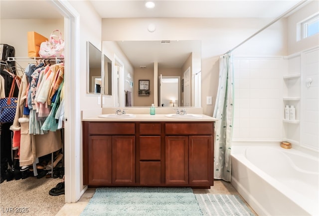bathroom featuring double vanity, shower / tub combo, and a spacious closet