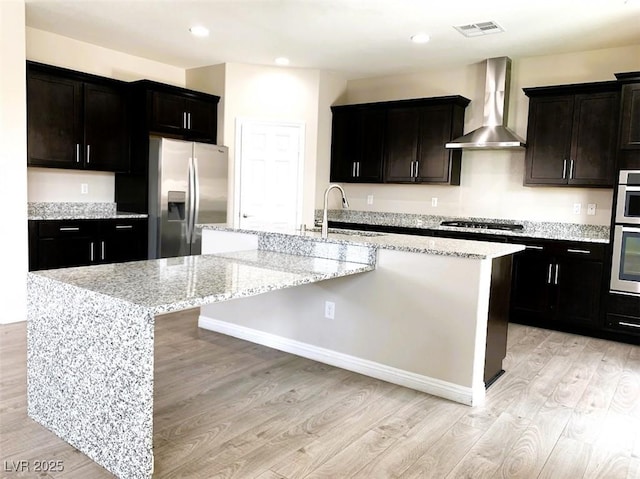 7861 Hamilton Pool Dr, Las Vegas, NV 89113 - kitchen featuring stainless steel fridge with ice dispenser, wall chimney range hood, a sink, gas stovetop, and light wood-style flooring