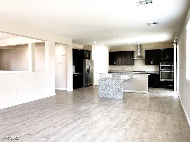 7861 Hamilton Pool Dr, Las Vegas, NV 89113 - kitchen featuring appliances with stainless steel finishes, wall chimney exhaust hood, a sink, light wood-style floors, and open floor plan