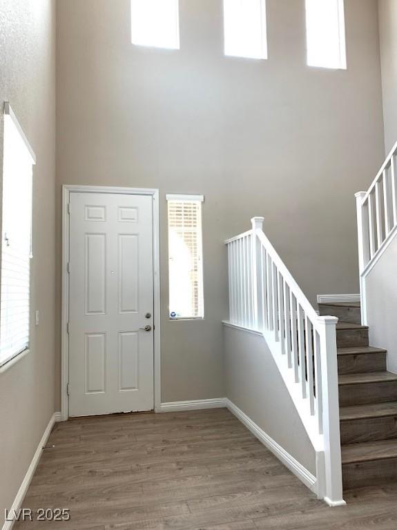 7861 Hamilton Pool Dr, Las Vegas, NV 89113 - foyer featuring wood finished floors, a high ceiling, stairway, and baseboards