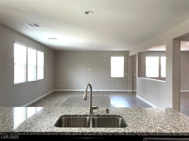 7861 Hamilton Pool Dr, Las Vegas, NV 89113 - kitchen with a sink, light stone countertops, and open floor plan
