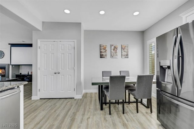 8836 Martin Downs Pl, Las Vegas, NV 89131 - dining space with light wood-style floors, baseboards, recessed lighting, and a glass covered fireplace
